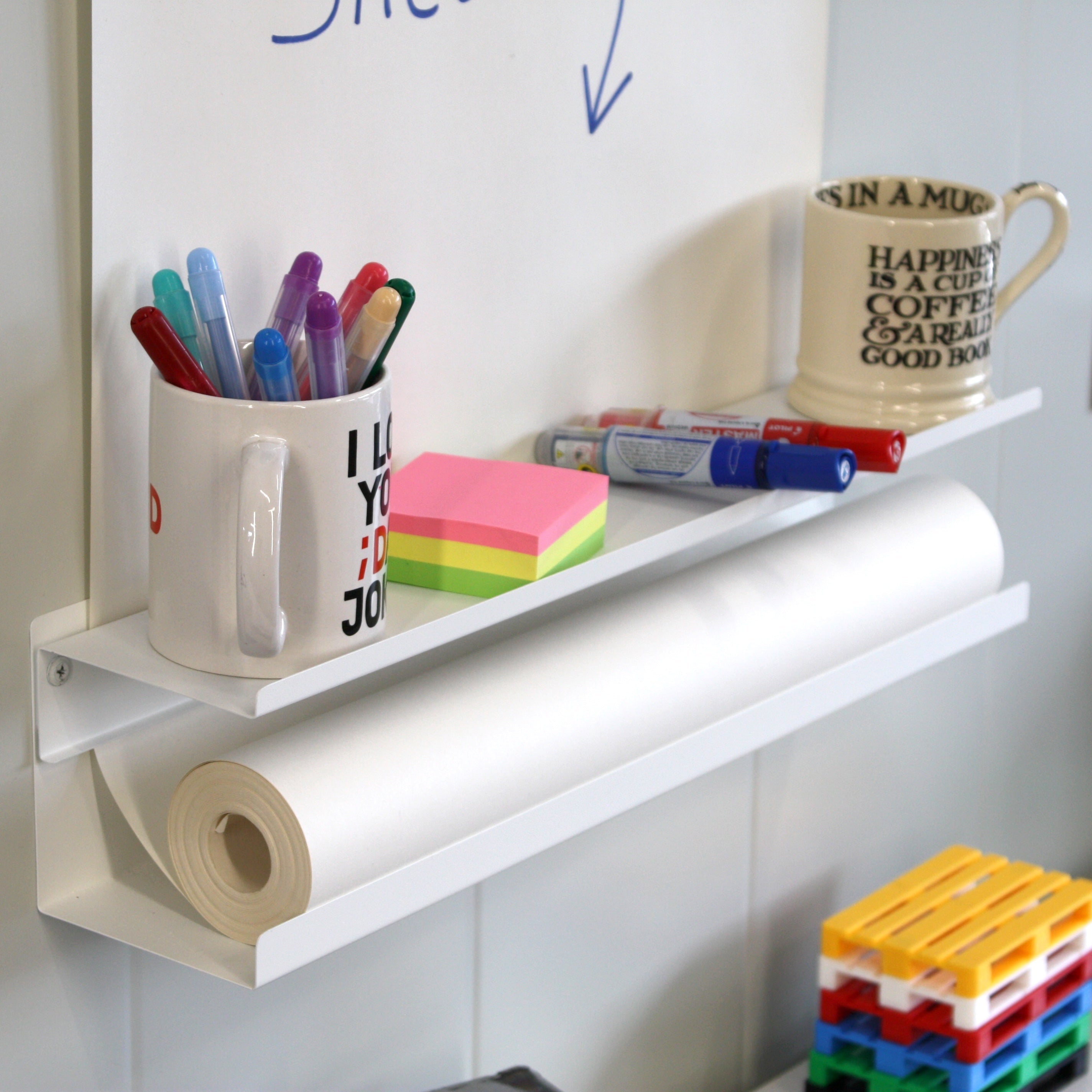 Bottom shelf. Space for pens, post-its, coffee. Also unused paper.