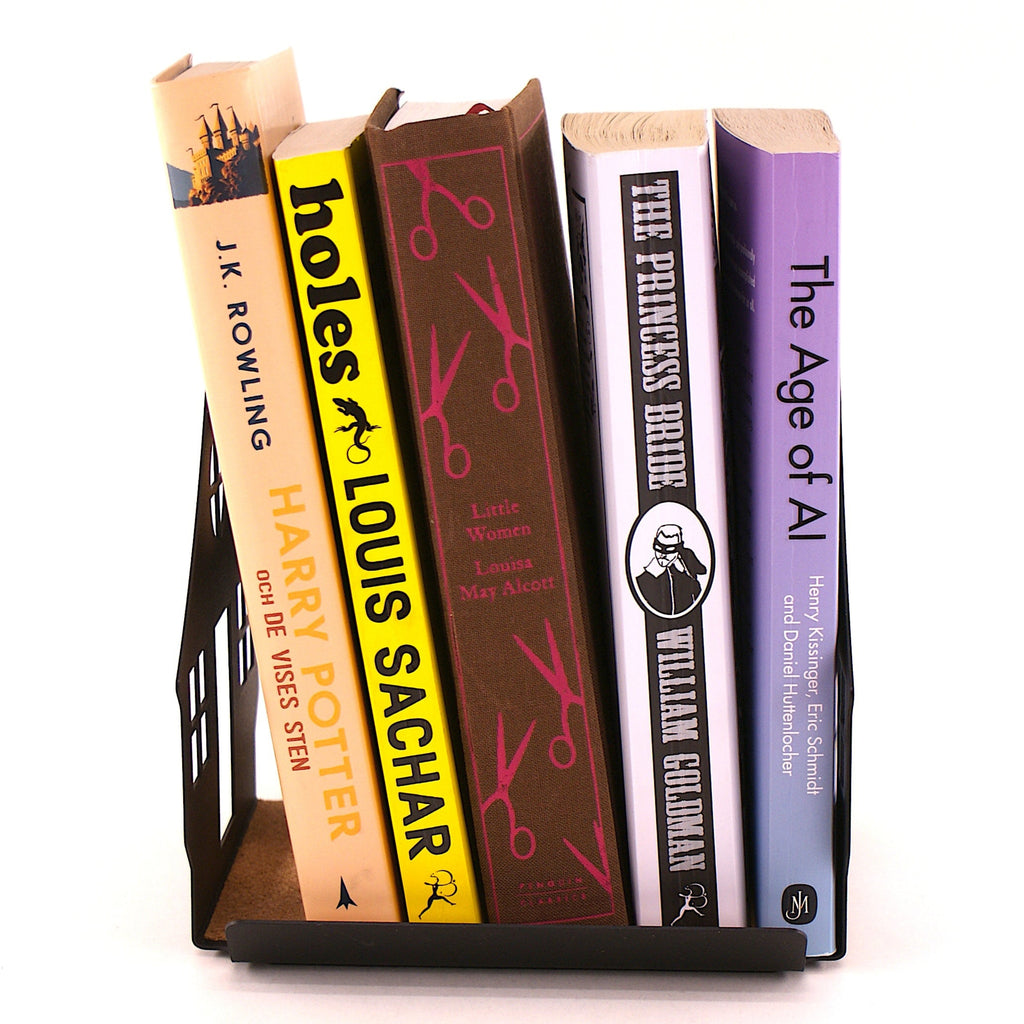 Books standing in a house shaped book rest on a white background.