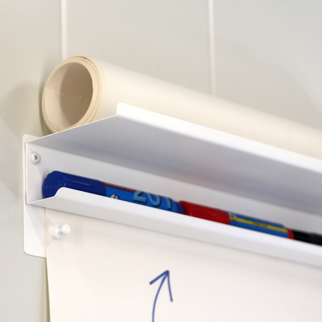 Top shelf with the roll of used paper and pens that should be kept away from the children.